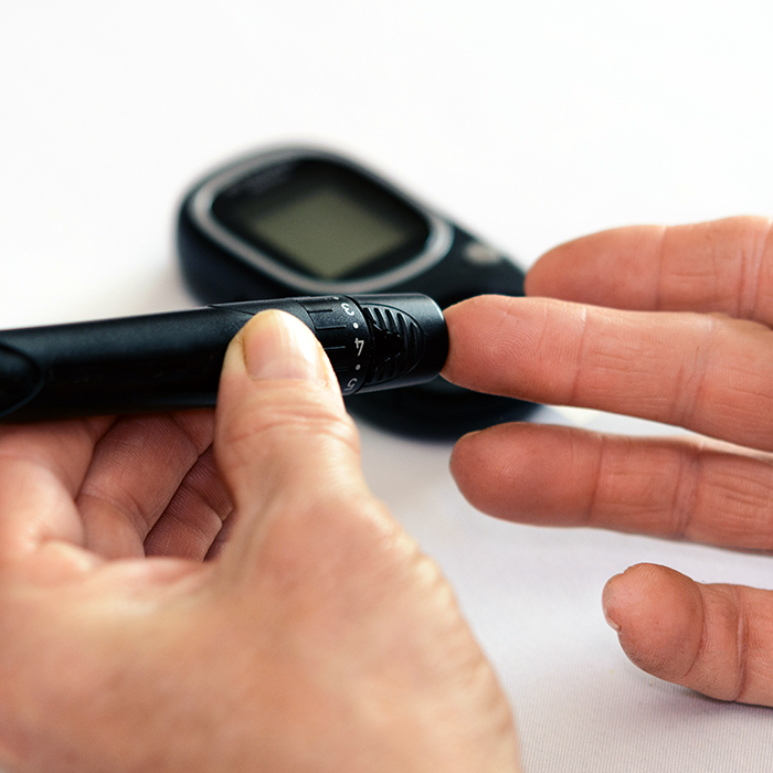 Woman testing blood sugar while considering Neurodon's curative potential for Diabetes